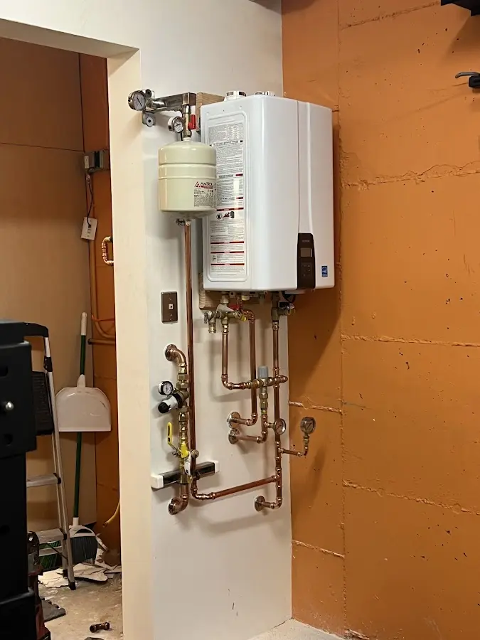 Plumbing technician inspecting water heater connections in Rossmoor